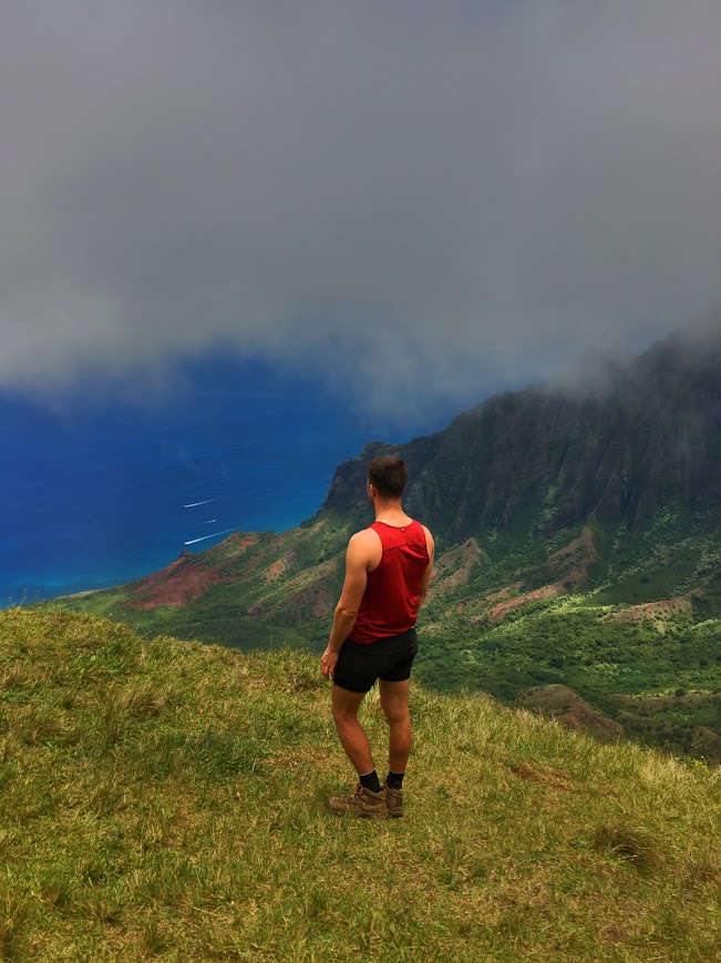 Above and Below Napali guest standing on a cliff